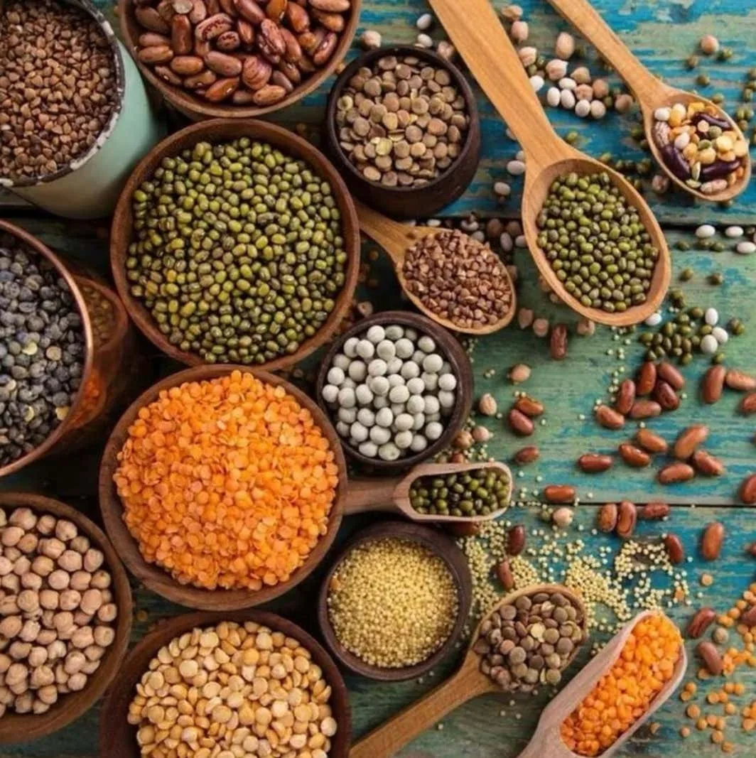 Assorted pulses and lentils in bowls and wooden spoons