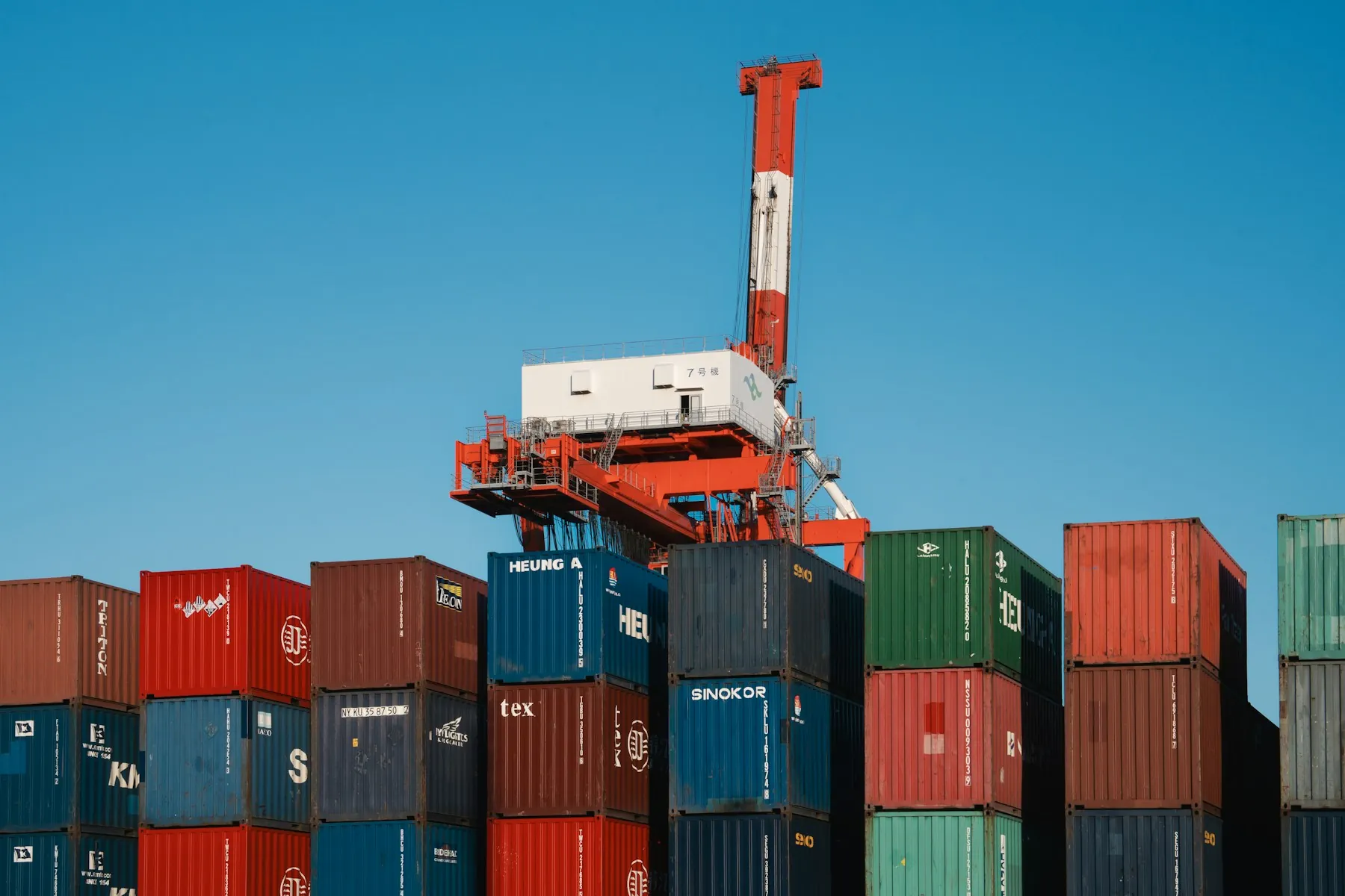 Stacked shipping containers beneath a port crane